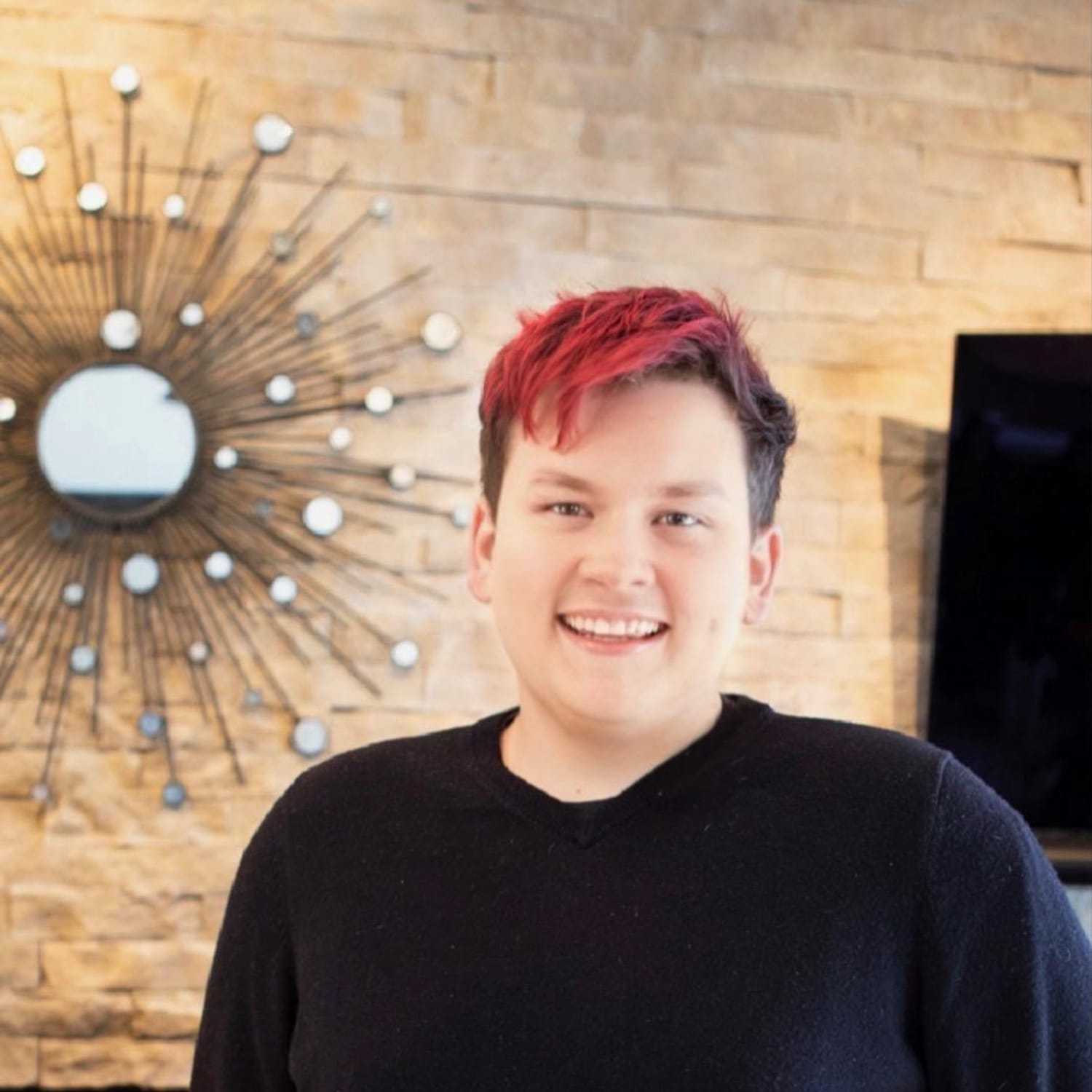 Portrait of Aiden Doloughty, a professional stylist at Studio Raw Elite, showcasing their expertise and style.